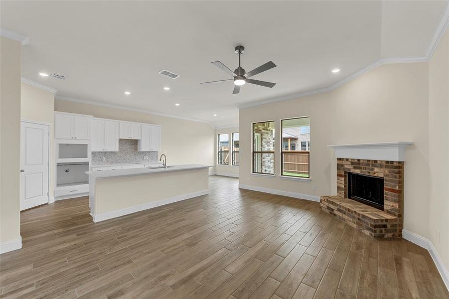 Open-concept living space featuring wood-finish flooring, a contemporary ceiling fan, and recessed lighting