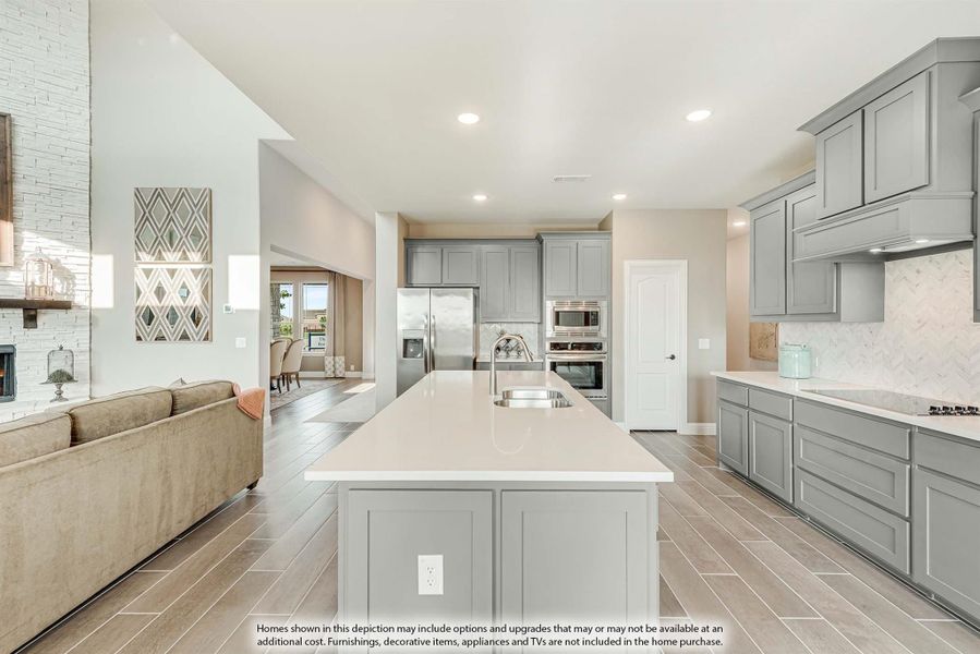 Open kitchen with gray cabinets, large center island, stainless appliances, and tile floors open to living room