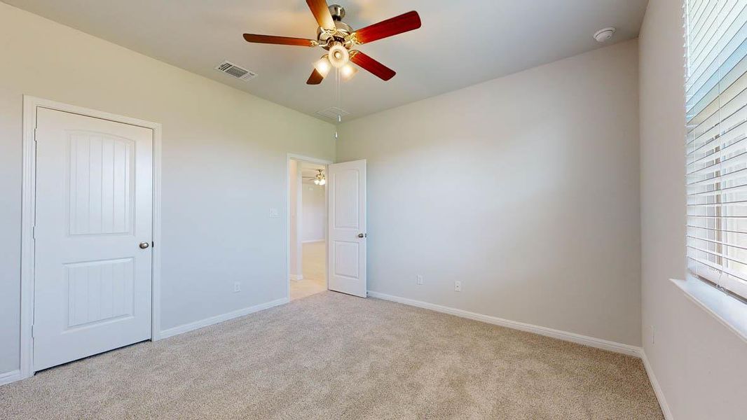 Unfurnished bedroom with light carpet and ceiling fan