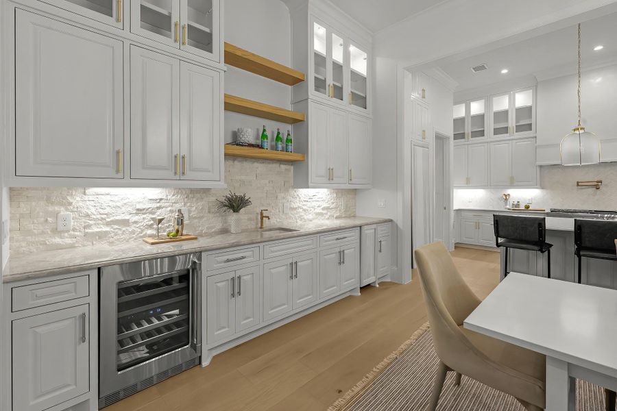 A convenient wet bar complete with wine fridge and separate ice maker making entertaining a breeze! Photo may be virtually staged A convenient wet bar complete with wine fridge and separate ice maker making entertaining a breeze! Photo may be virtually staged