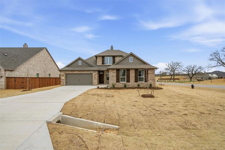 Craftsman inspired home featuring driveway, a garage, and roof with shingles