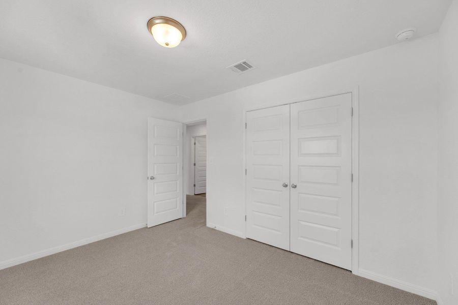 Unfurnished bedroom with carpet floors and a closet Unfurnished bedroom with carpet floors and a closet