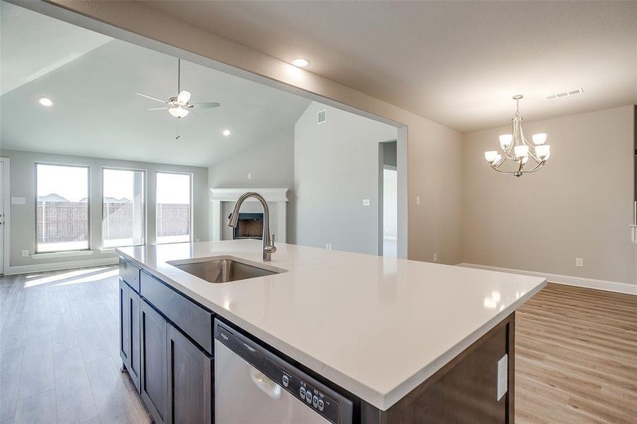 wood-style floors, an island with sink, and pendant lighting wood-style floors, an island with sink, and pendant lighting