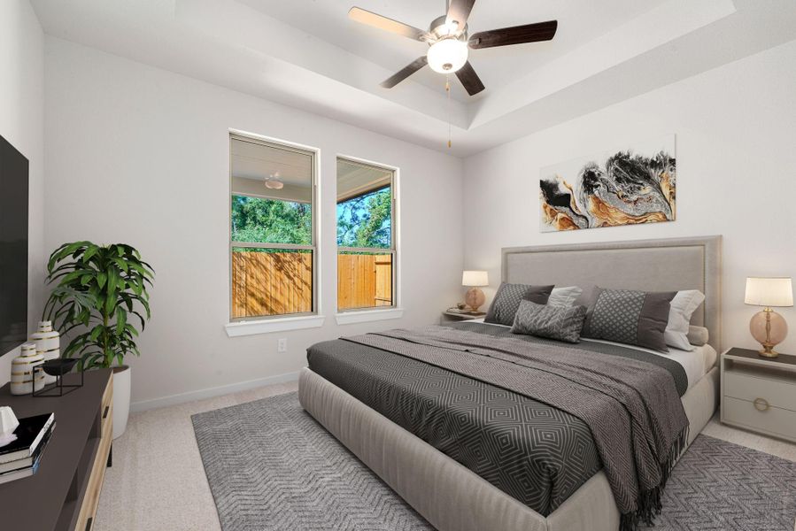 The serene primary suite offers a peaceful retreat with soft natural light, neutral tones, and a tray ceiling that adds a touch of elegance. Its spacious layout provides the perfect blend of comfort and relaxation.