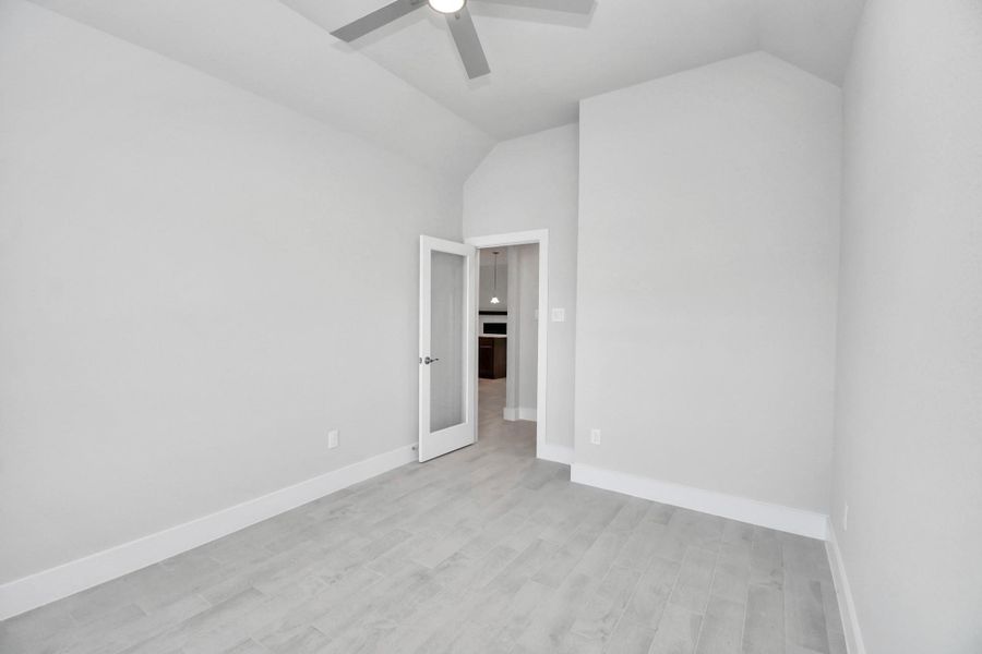 Experience the perfect blend of sophistication and warmth in this home office, boasting elegant wood-look tile flooring and flooded with natural light from expansive windows and French doors. Sample photo of completed home with similar floor plan. Actual colors and selections may vary.