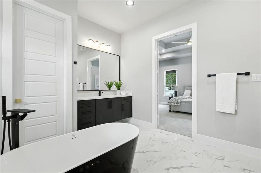 Ensuite bathroom with vanity, a soaking tub, light marble finish flooring, and recessed lighting
