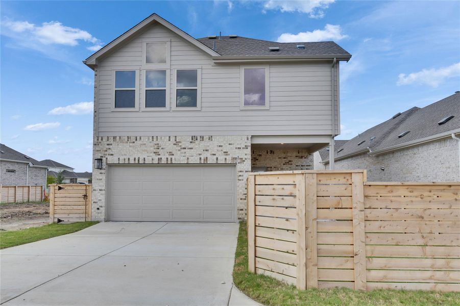 View of front of house featuring concrete driveway, a garage, brick siding, and a shingled roof