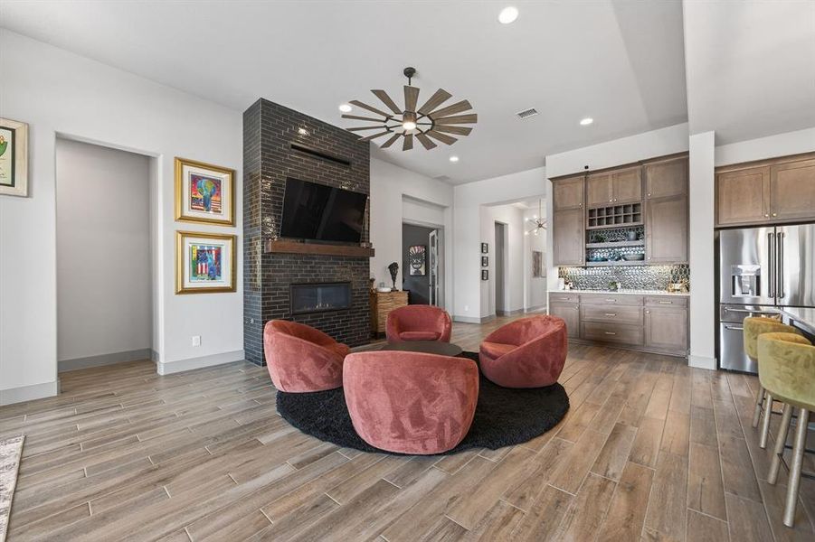 Living area anchored by floor-to-ceiling tiled fireplace and custom wine cabinet. Living area anchored by floor-to-ceiling tiled fireplace and custom wine cabinet.