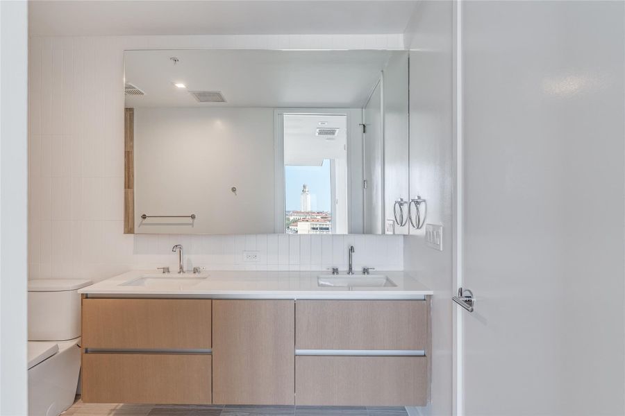 A well-appointed primary bathroom featuring a double vanity with ample storage. A well-appointed primary bathroom featuring a double vanity with ample storage.