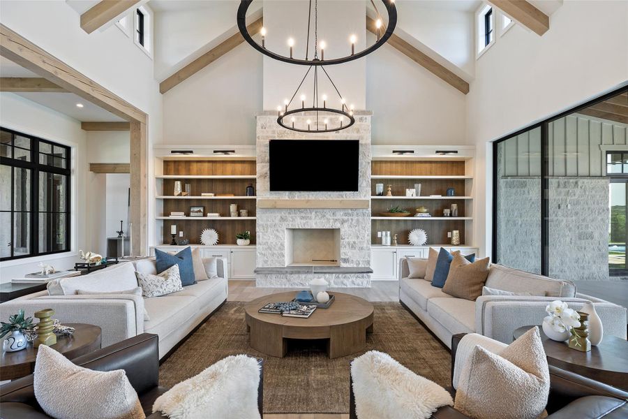 Living room with high vaulted ceiling, plenty of natural light, a stone fireplace, beam ceiling, and wood finished floors