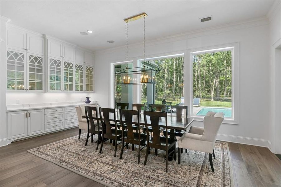 The large charming dining room offers more glass front cabinets, Quartz counters, and more storage. This buffet is also the perfect place to serve your meals, desserts or have a coffee bar. Unique light fixture!