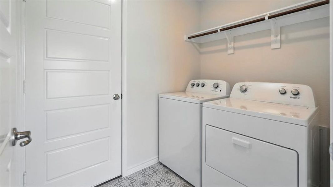Laundry room featuring washing machine and dryer and baseboards