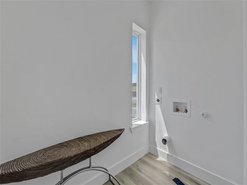 Laundry room with light hardwood / wood-style floors, electric dryer hookup, and hookup for a washing machine