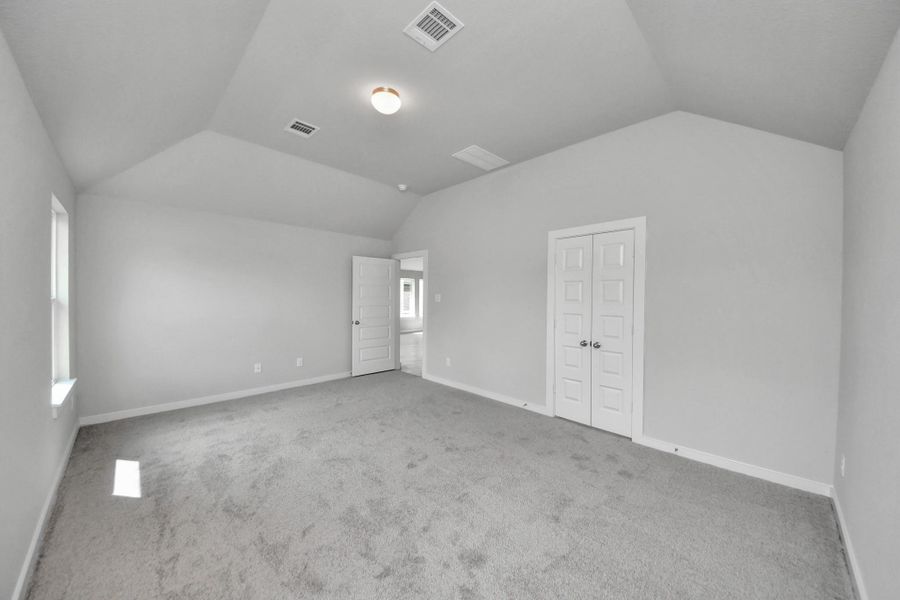 Escape to tranquility in this spacious primary room, adorned with plush carpeting and bathed in the soothing hues of warm paint colors, creating a cozy retreat for relaxation. Sample photo of completed home with similar floor plan. Actual colors and selections may vary.