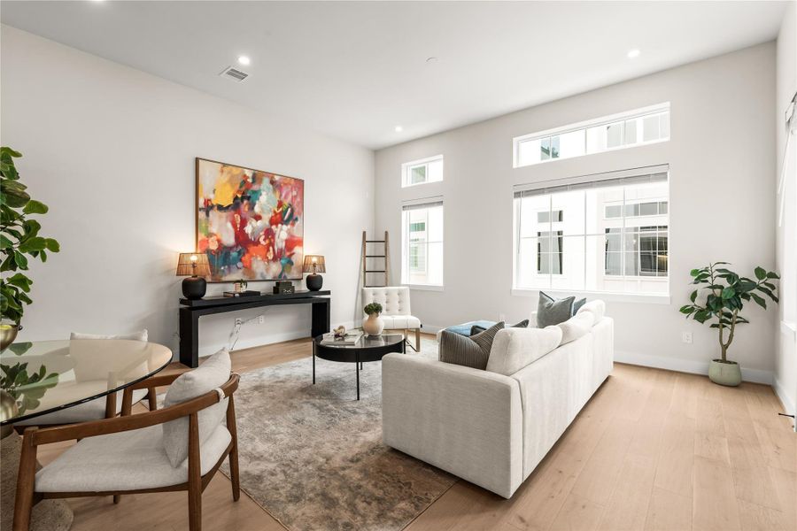 Tall windows paired with transoms draw light deeper into the living room while preserving ample wall space for furniture and media placement.