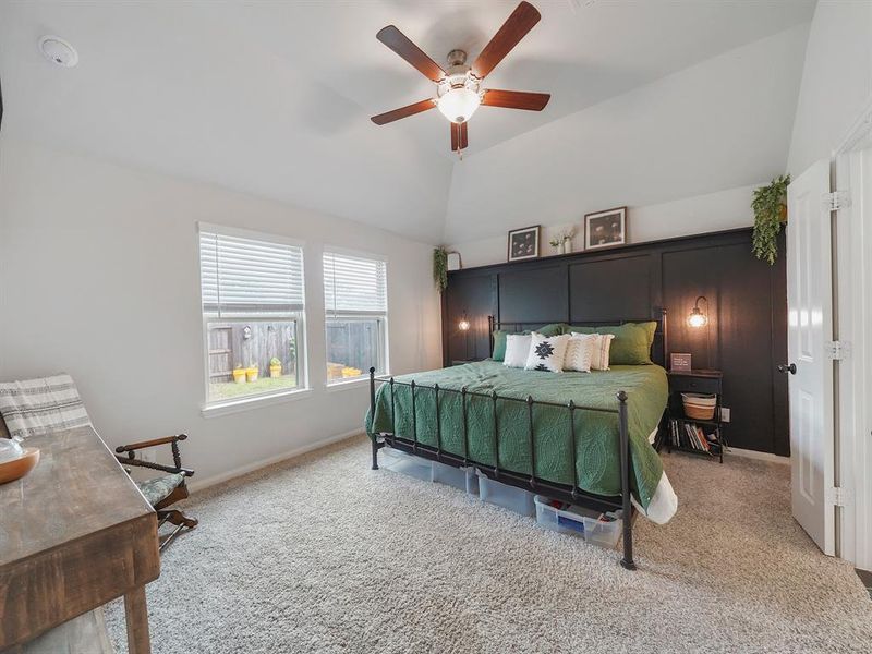 The primary bedroom has a gorgeous accent wall, beautiful lighting, and a newly installed fan.