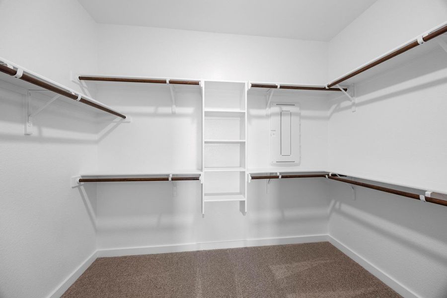 Ample storage solutions abound in this well-appointed walk-in closet, featuring multiple shelving units and hanging rods. Ample storage solutions abound in this well-appointed walk-in closet, featuring multiple shelving units and hanging rods.