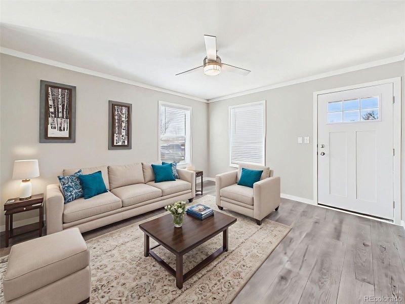 Virtually Staged Living Room – This rendered setup illustrates a warm and comfortable seating area just inside the front door, ideal for casual gatherings or relaxing evenings.