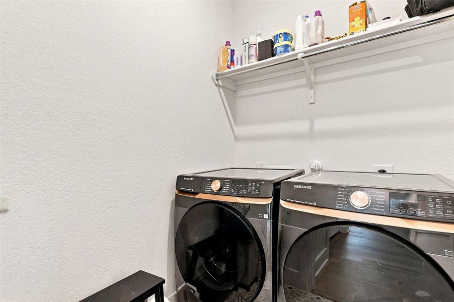 Functional utility space includes built-in wire shelving above modern appliances and tile flooring.