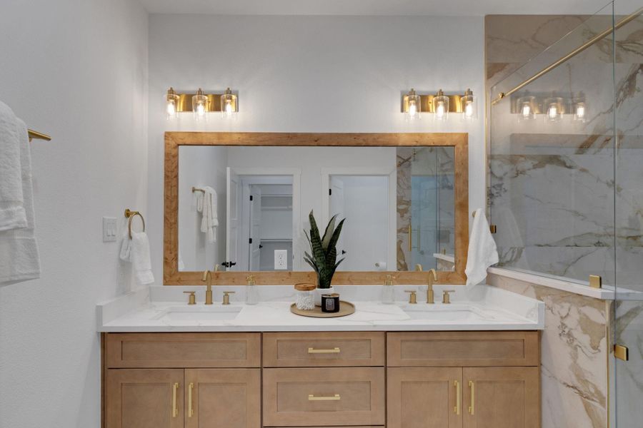 Luxurious primary bath with dual vanity, quartz counters, and gold accents for a spa-like feel. Luxurious primary bath with dual vanity, quartz counters, and gold accents for a spa-like feel.