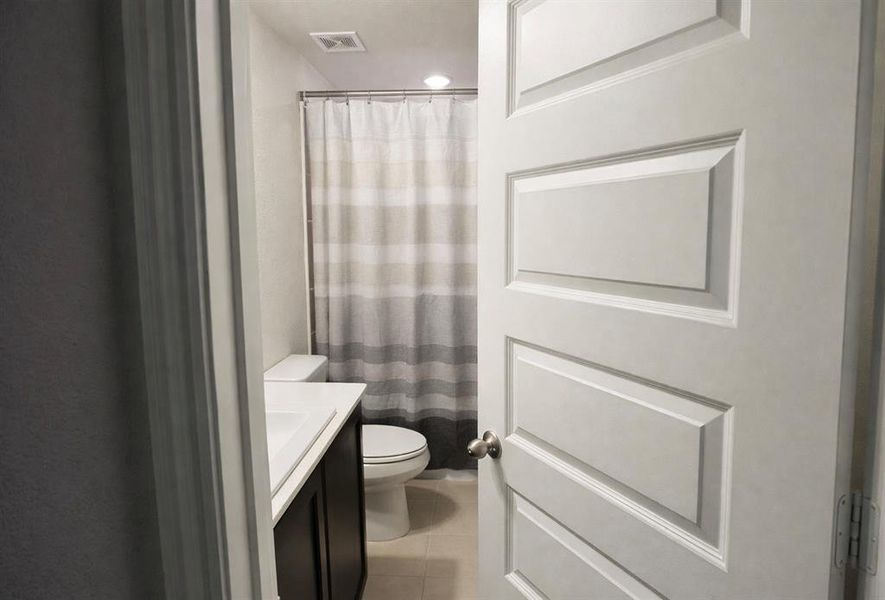 Full bath featuring a shower with shower curtain, vanity, light tile patterned flooring, and recessed lighting