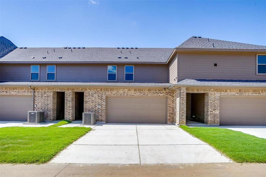 Traditional-style home with driveway, brick siding, a shingled roof, and a garage Traditional-style home with driveway, brick siding, a shingled roof, and a garage