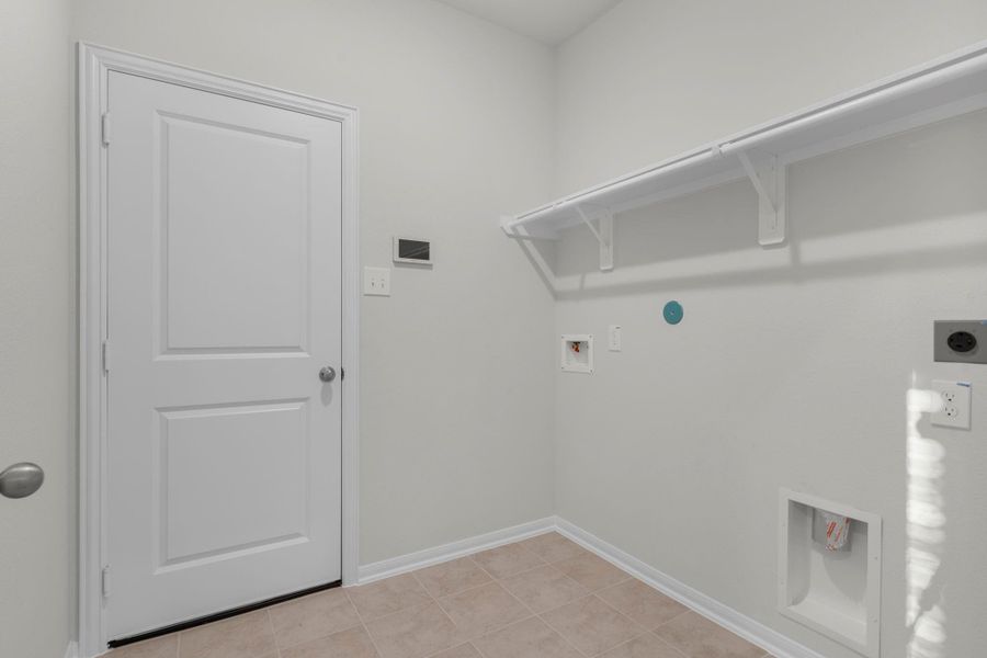 The utility room is conveniently located on the first floor and offers space for a full-size washer and dryer along with built-in shelving for added storage. Its practical design keeps laundry day simple and organized while maintaining a clean, modern look. The utility room is conveniently located on the first floor and offers space for a full-size washer and dryer along with built-in shelving for added storage. Its practical design keeps laundry day simple and organized while maintaining a clean, modern look.