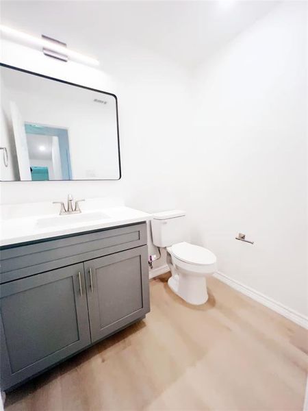 Bathroom featuring a single vanity with gray cabinetry, white countertop, and integrated sink