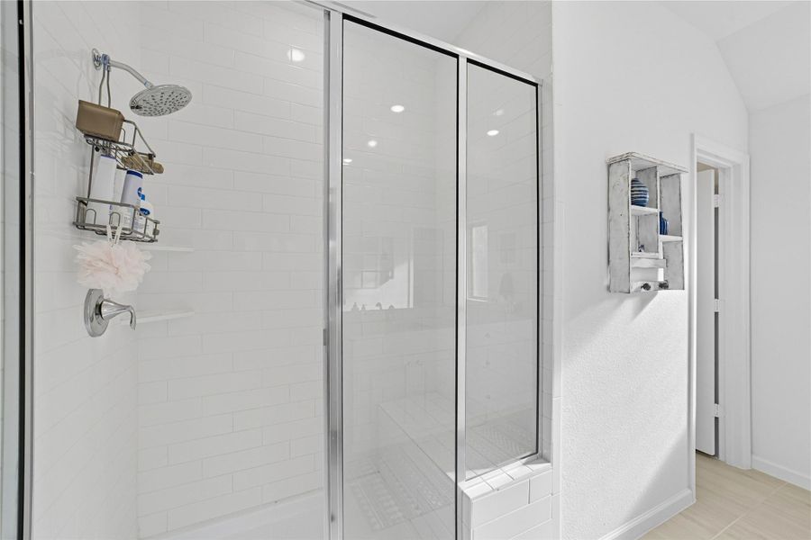 The master bath includes a spacious glass-enclosed shower featuring white subway tiles. The master bath includes a spacious glass-enclosed shower featuring white subway tiles.