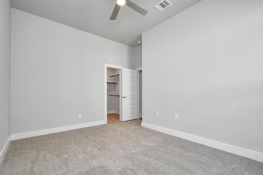 Generously sized secondary bedrooms featuring spacious closets, soft and inviting carpeting underfoot, large windows allowing plenty of natural light, and the added touch of privacy blinds for your personal retreat. Sample photo of completed home with similar plan. As built color and selections will vary.