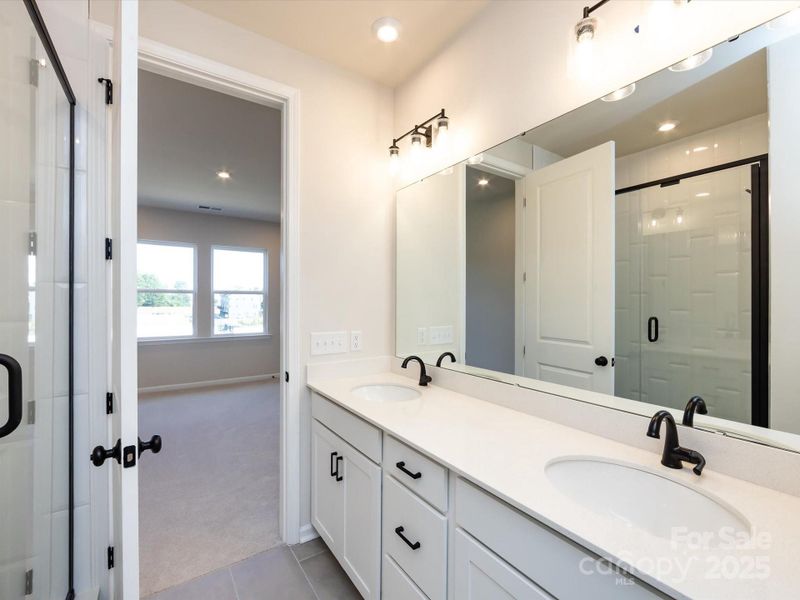 Primary En Suite Bath Featuring Dual Vanity and Loads of Storage.