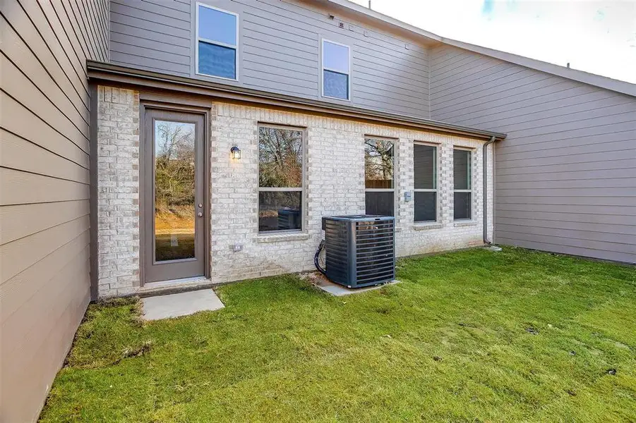 Doorway to property featuring a lawn and brick siding Doorway to property featuring a lawn and brick siding