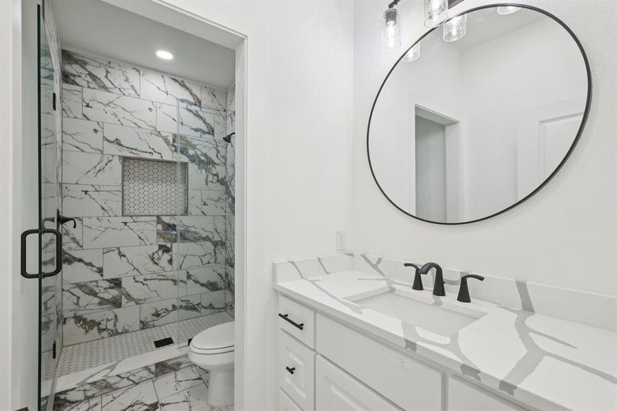 Bathroom with light marble finish floors, a stall shower, vanity, and recessed lighting