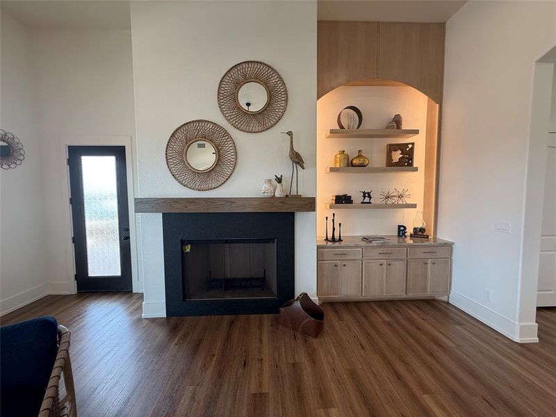 Living room with dark wood-type flooring and a glass covered fireplace Living room with dark wood-type flooring and a glass covered fireplace