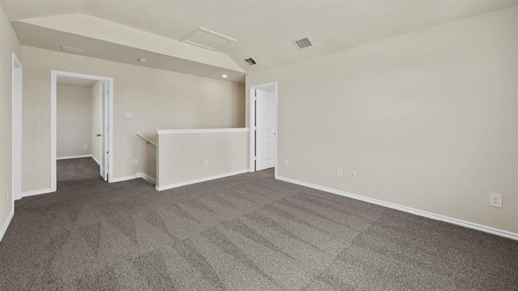 Spacious carpeted room featuring neutral wall tones, white trim, and recessed lighting