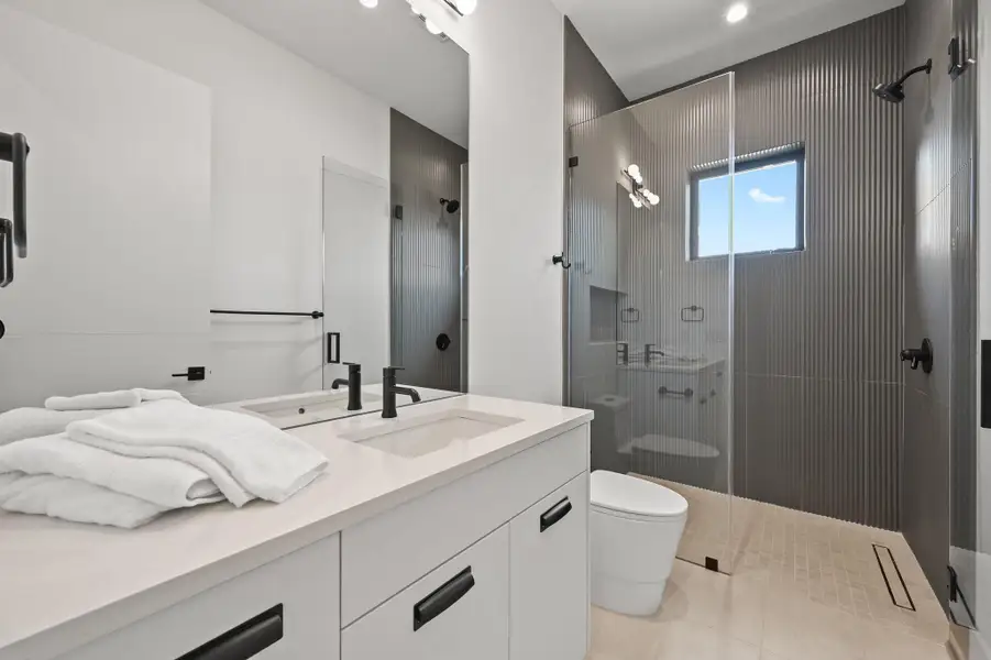 Bathroom featuring a stall shower, vanity, and light tile patterned floors
