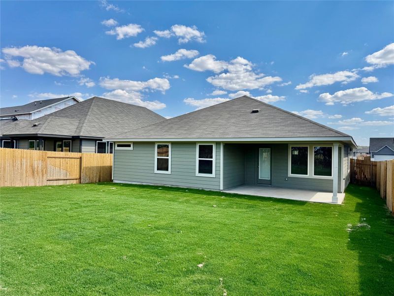 Rear view of house with a fenced backyard, roof with shingles, and a patio area Rear view of house with a fenced backyard, roof with shingles, and a patio area