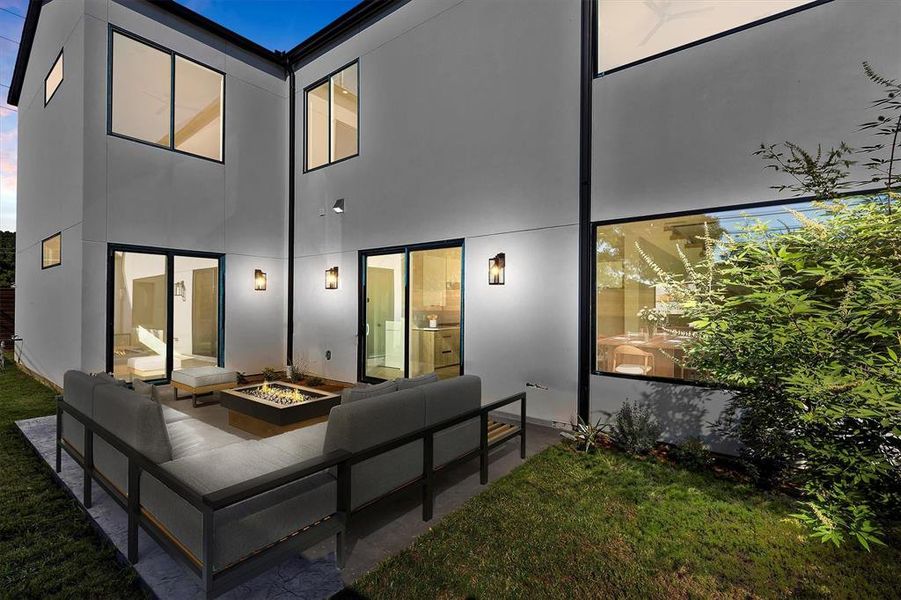 Rear view of house with a patio, a yard, and an outdoor living space with a fire pit