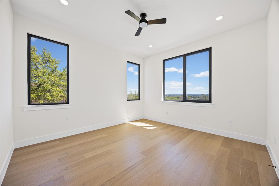 Spare room with light wood-style flooring, a ceiling fan, healthy amount of natural light, and recessed lighting