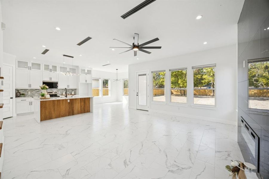 Unfurnished living room with light marble finish flooring, recessed lighting, and a ceiling fan
