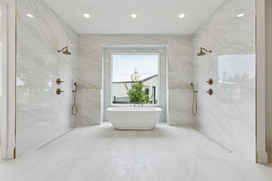 Incredible ensuite bath with separate vanities, a double shower, and soaking tub.