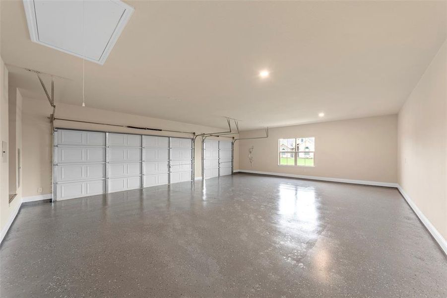 Garage featuring baseboards and recessed lighting