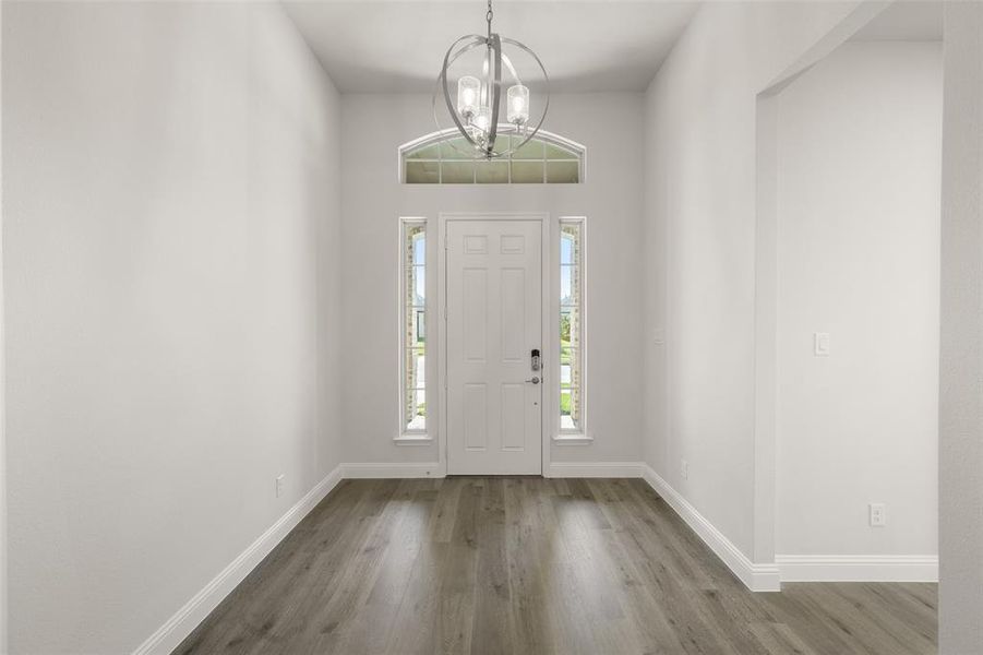 Entryway featuring a chandelier and wood finished floors Entryway featuring a chandelier and wood finished floors