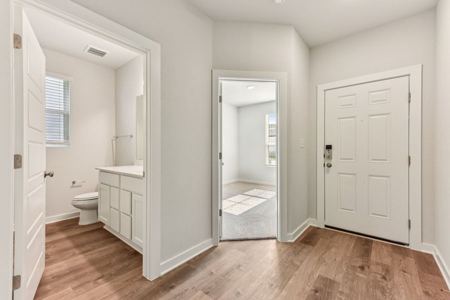 A bathroom with white cabinets.