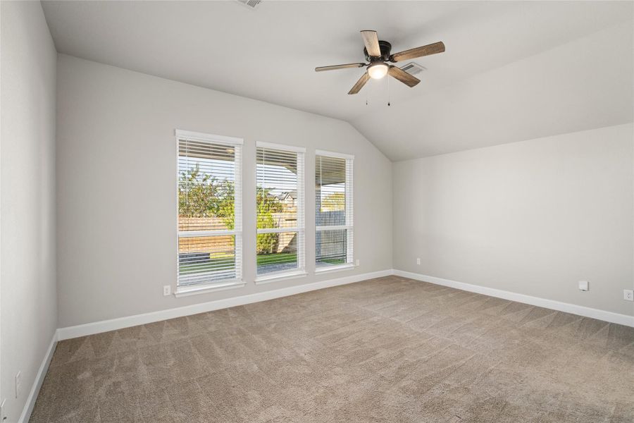 Primary Suite Oasis: Spacious bedroom boasting a beautiful Wall of Windows and vaulted ceilings.
