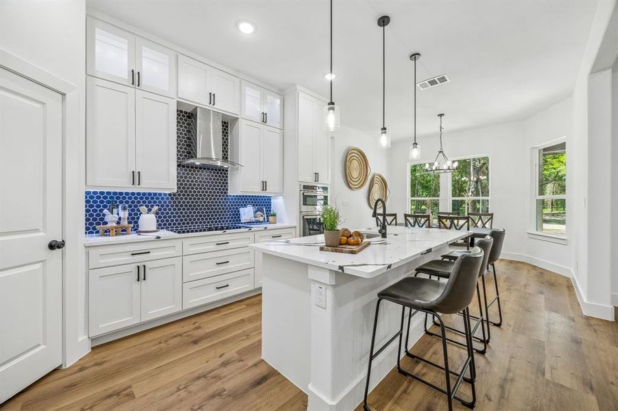 The kitchen features white shaker cabinetry and stainless steel appliances