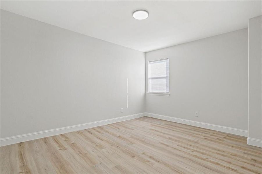 Empty room with light hardwood / wood-style flooring