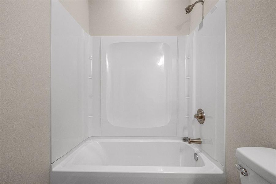 Bathroom featuring toilet and shower / washtub combination