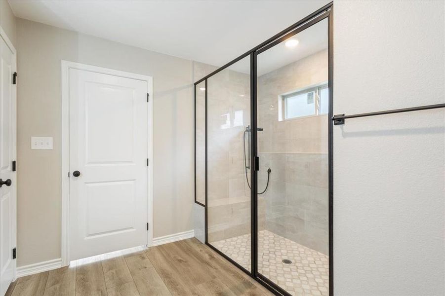 Full bath with a shower stall and wood finished floors Full bath with a shower stall and wood finished floors