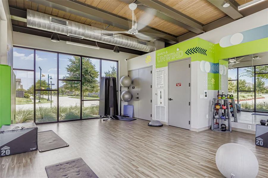 Gym featuring wood finished floors and beamed ceiling